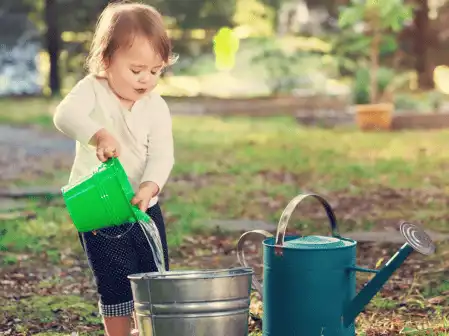 a young child with a watering pot