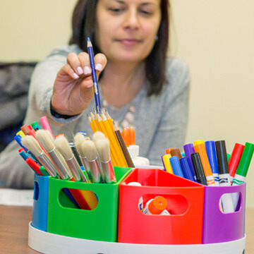 Teacher placing pencil in create a space storage center