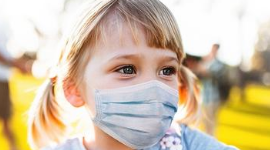 A young girl with a face mask on