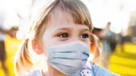 A young girl with a face mask on
