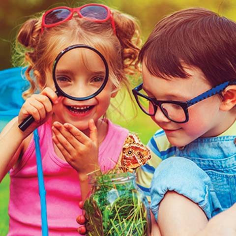 Preschool children looking through magnifying glass