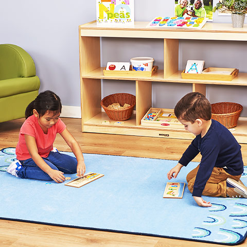 Preschool children playing with puzzles on a carpet