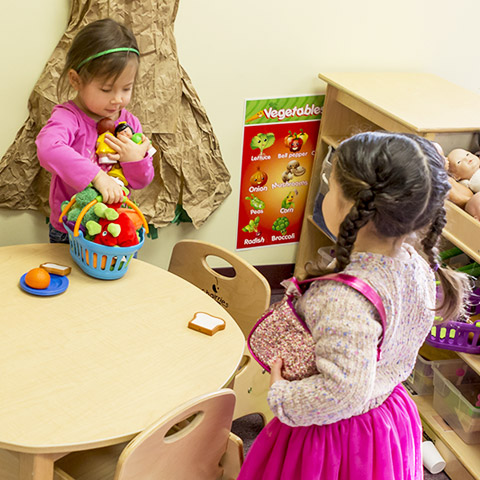 Preschool children playing in dramatic play learning center