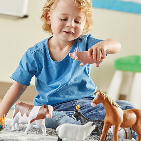 Preschool children playing with Jumbo Farm Animals