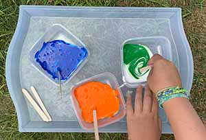 Stirring tempera paint into bowls with white glue