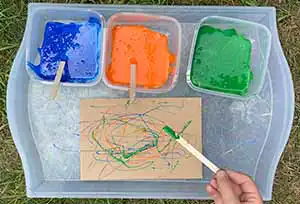 Artful Goods craft sticks drizzling colored glue on paper