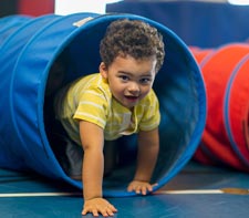 Preschool child climbing in a tunnel