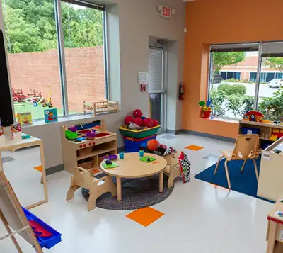 Preschool classroom with tables, storage and books