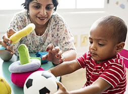 Toddler child playing with teacher