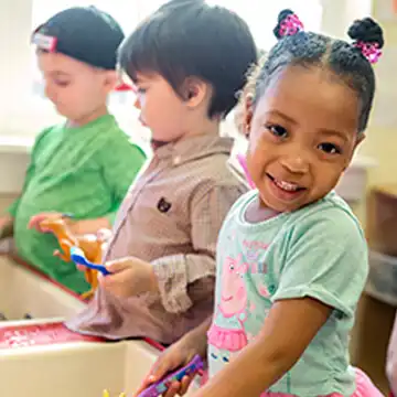 Preschool children playing at sand & water table