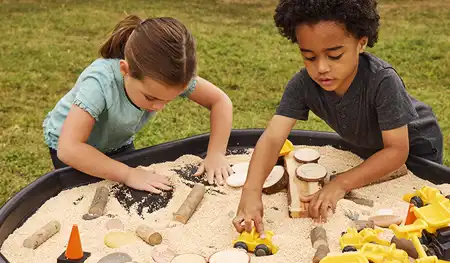 Children enjoying sensory play outside with in a Tuff Tray from Becker’s School Supplies. 