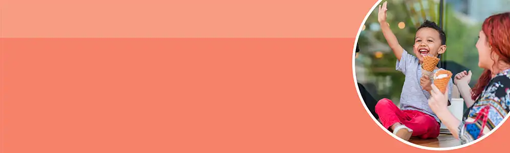 Preschool child eating ice cream with two women