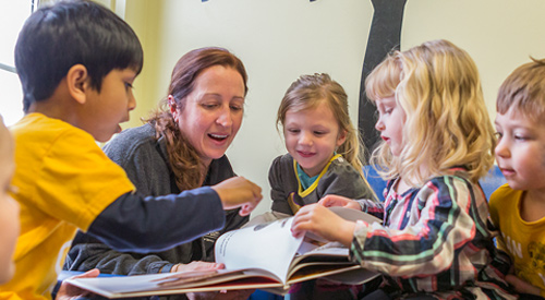 Preschool teacher reading to a group of children