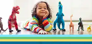 Preschool child on floor with dinosaur figures